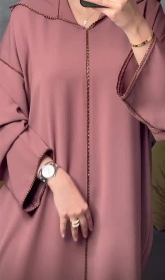 Gracieuse et sophistiquée, cette djellaba marocaine ;présente un travail de broderie délicat et une finition crepe coria luxueuse.