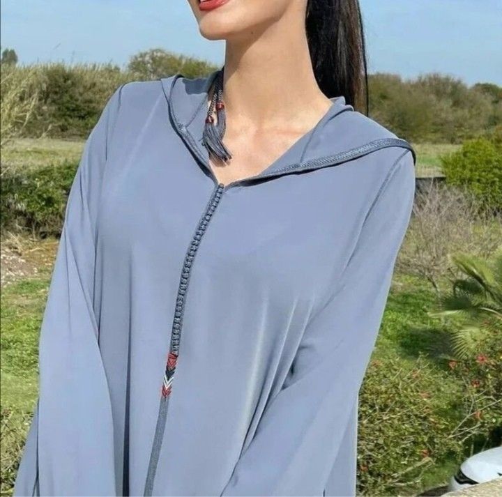 Gracieuse et sophistiquée, cette djellaba marocaine ;présente un travail de broderie délicat et une finition crepe coria luxueuse.