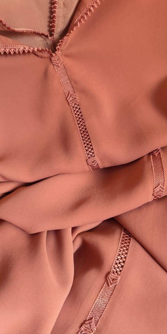 Gracieuse et sophistiquée, cette djellaba marocaine ;présente un travail de broderie délicat et une finition crepe coria luxueuse.